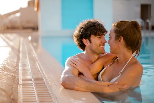 男人和女人在游泳池拥抱 · 免费素材图片