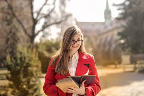 红色西装外套拿着书的女人 · 免费素材图片