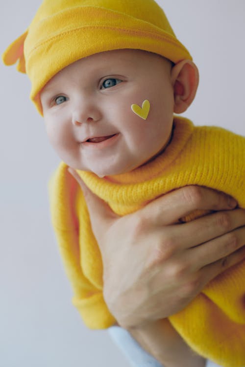 婴儿的黄色针织帽和黄色的针织毛衣 · 免费素材图片