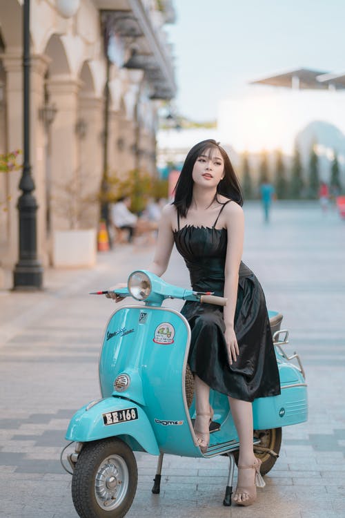 穿裙子坐在蓝色小型摩托车上的女人 · 免费素材图片