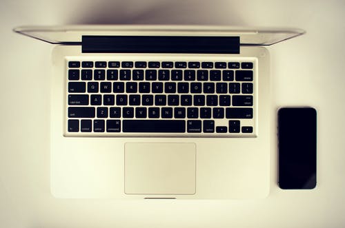黑色android智能手机旁边的白色笔记本计算机 · 免费素材图片