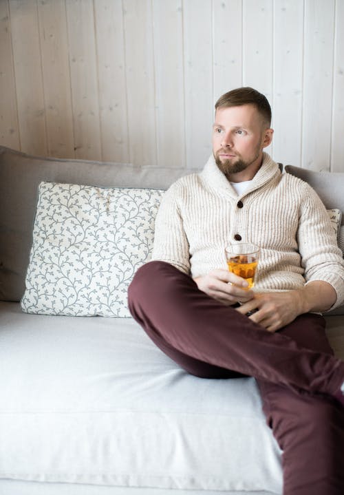 男子坐在沙发上的照片 · 免费素材图片