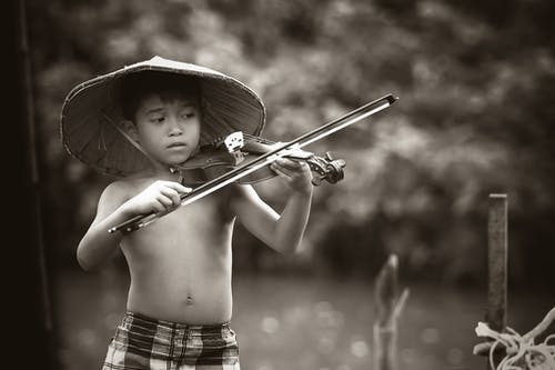 男孩弹小提琴的灰度摄影 · 免费素材图片