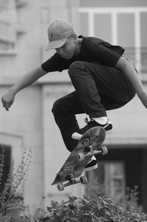跳与滑板的黑衬衫的男人 · 免费素材图片