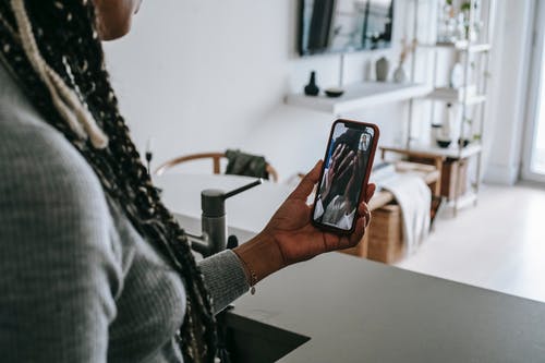匿名黑人女性在家里的智能手机上有视频聊天 · 免费素材图片