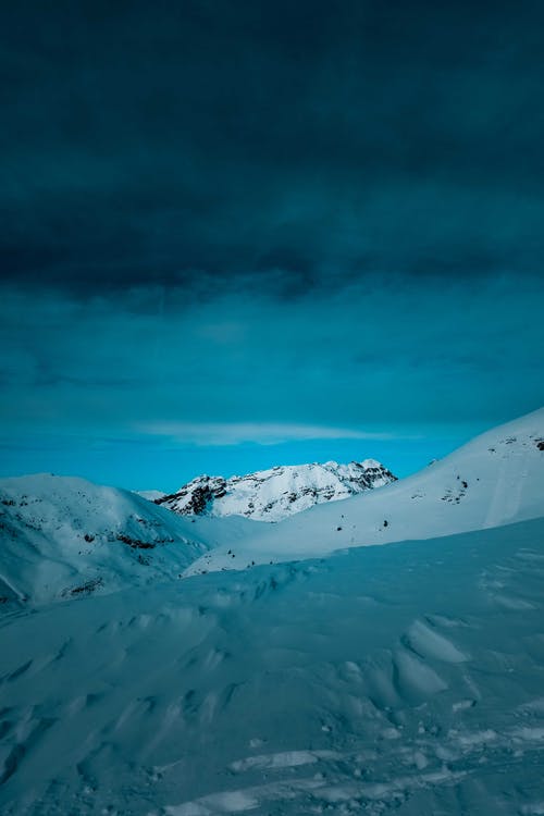 多云的天空下的积雪的山 · 免费素材图片