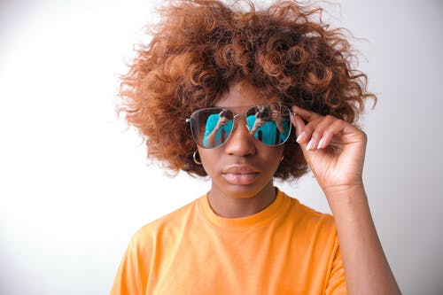橙色穿圆领衬衫，戴着蓝色太阳镜的女人 · 免费素材图片