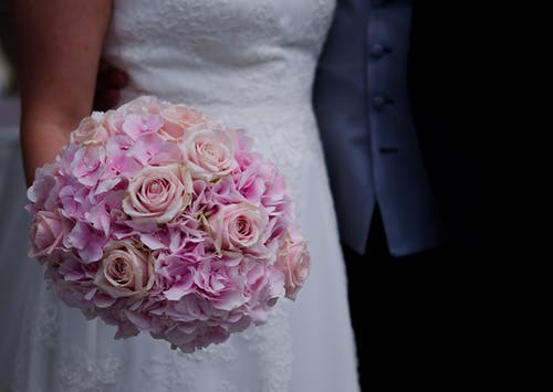 拿着一束鲜花的白色婚纱的女人 · 免费素材图片