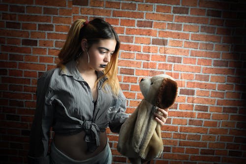 女人看，抱着棕色的狗毛绒玩具 · 免费素材图片