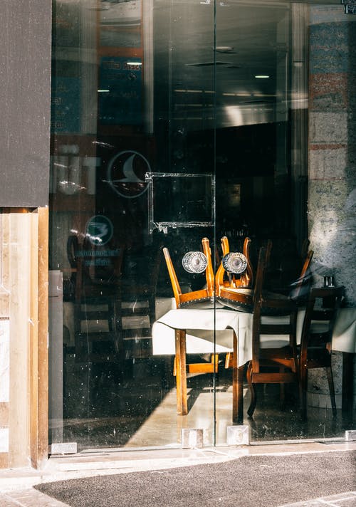 玻璃窗旁边的棕色木椅 · 免费素材图片