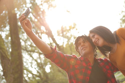 男人和女人拍照使用智能手机的照片 · 免费素材图片
