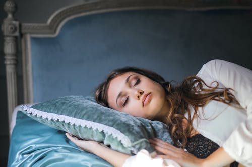 白色丝绸长袍，睡在床上的女人的特写照片 · 免费素材图片