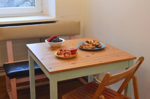 棕色的木桌上红色和白色的陶瓷碗和盘子 · 免费素材图片