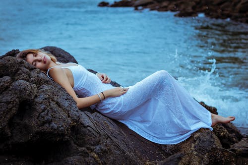 躺在岩石上的女人的照片 · 免费素材图片