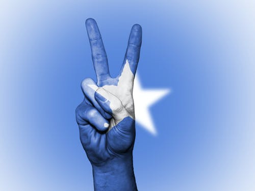 蓝色和白色的星星画手中的和平标志手势 · 免费素材图片