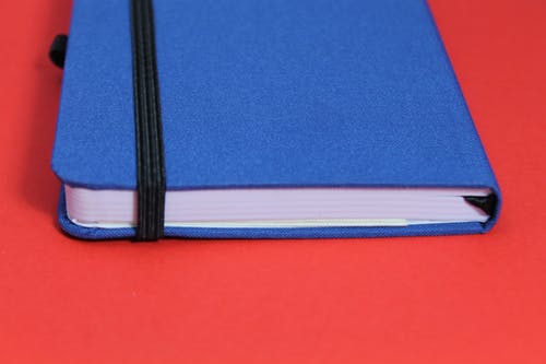 红色表面上的蓝色笔记本 · 免费素材图片