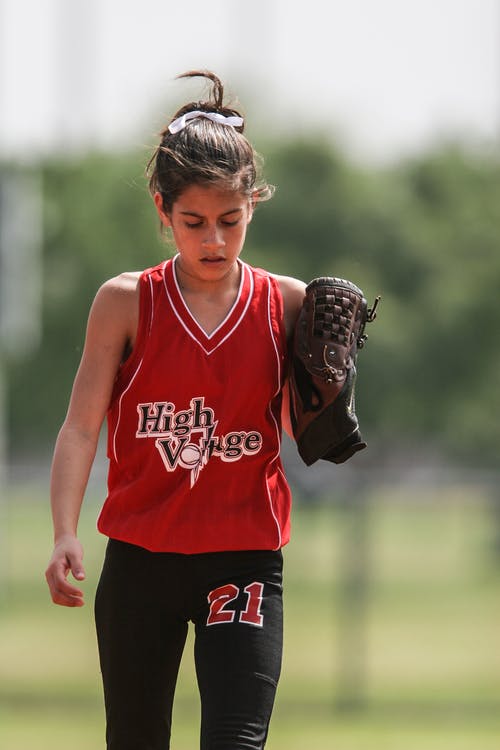 红色和黑色垒球统一行走的女孩 · 免费素材图片
