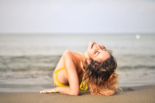 躺在海边的黄色比基尼的女人 · 免费素材图片