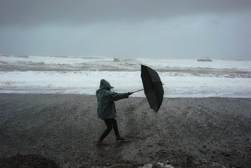在海滩上的雨伞变得面目全非的人 · 免费素材图片
