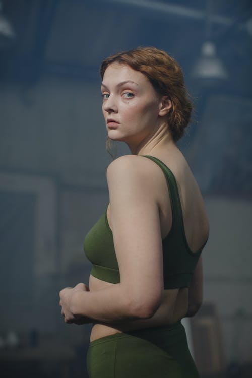 女人穿着绿色运动胸罩的照片 · 免费素材图片