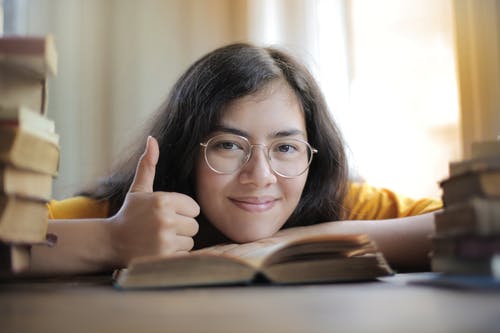 女人在做大拇指时微笑的选择性焦点照片 · 免费素材图片