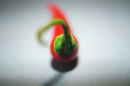 白色表面上的红辣椒的选择性聚焦摄影 · 免费素材图片