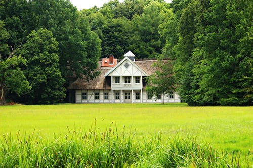 草场附近的白色和棕色混凝土房子 · 免费素材图片