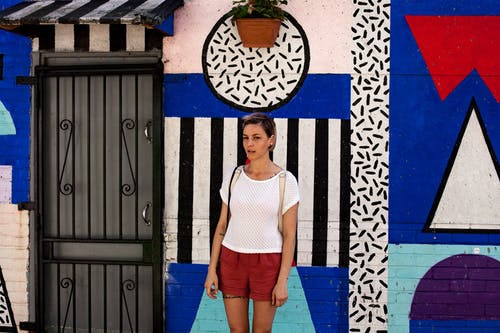 白顶站在粉刷墙壁附近的女人 · 免费素材图片