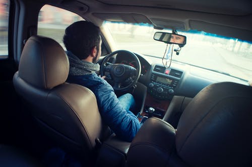 开车时坐在车内的男人穿蓝夹克 · 免费素材图片
