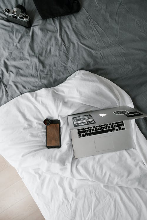 白色亚麻iphone旁边的macbook · 免费素材图片