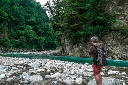 男人盯着户外水流 · 免费素材图片