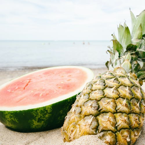 在海边切西瓜和菠萝 · 免费素材图片