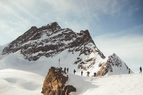 在雪山上行走的人 · 免费素材图片