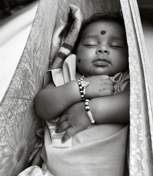 婴儿躺在吊床上的灰度照片 · 免费素材图片