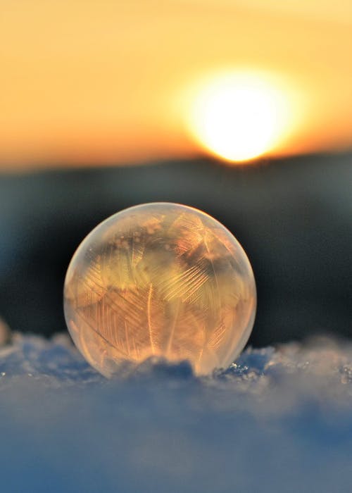冷冻的肥皂泡，在日落的天空 · 免费素材图片