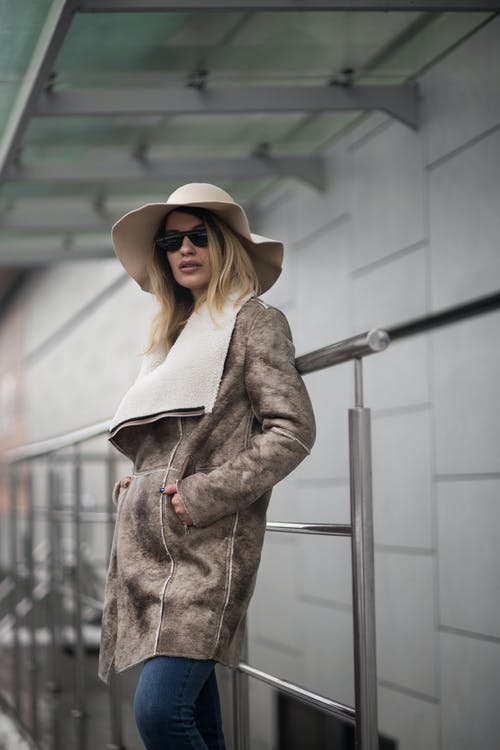 棕色麂皮大衣和太阳帽的女人 · 免费素材图片