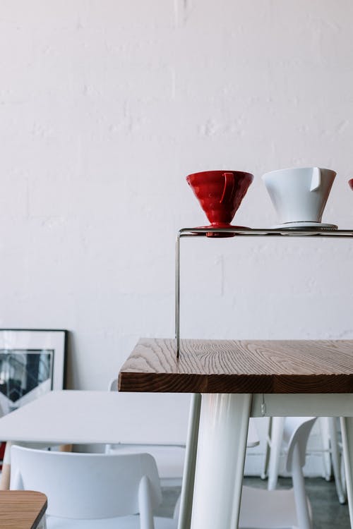 棕色木制的桌子上的红色和白色陶瓷杯 · 免费素材图片