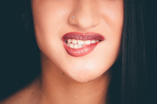女人用鼻子别针咬红唇 · 免费素材图片
