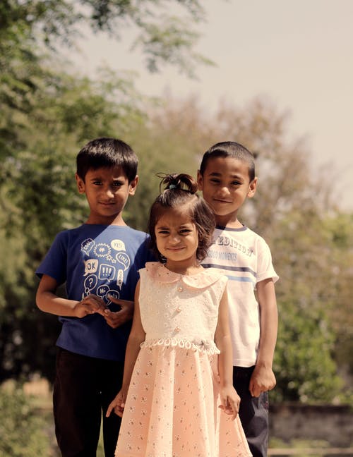 三个孩子站在树旁边 · 免费素材图片