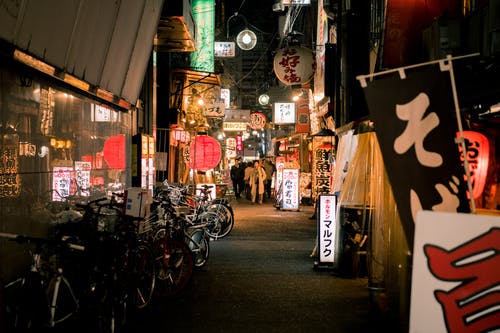 夜间在日本商店附近停放的自行车 · 免费素材图片