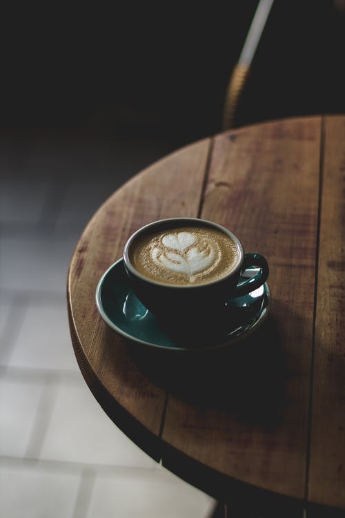 圆形蓝绿色和白色陶瓷茶杯与茶碟套装里面的咖啡 · 免费素材图片