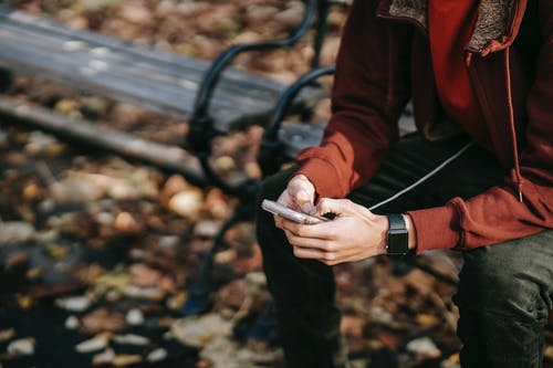 拿着香烟棒的红色夹克的人 · 免费素材图片