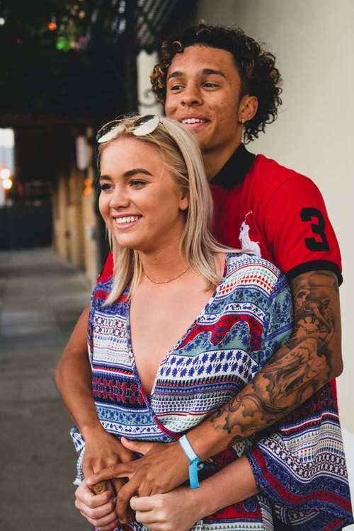 女人站在男人面前移交手臂 · 免费素材图片