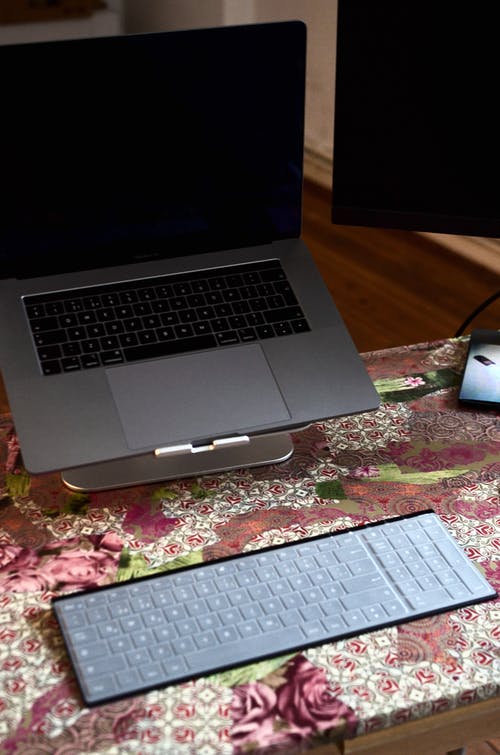 Macbook Pro棕色木制的桌子上 · 免费素材图片