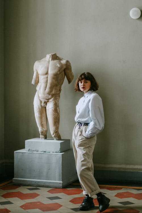 站在雕塑旁边的女人 · 免费素材图片