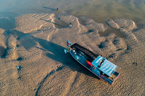 在海水附近的沙质海岸上划船 · 免费素材图片