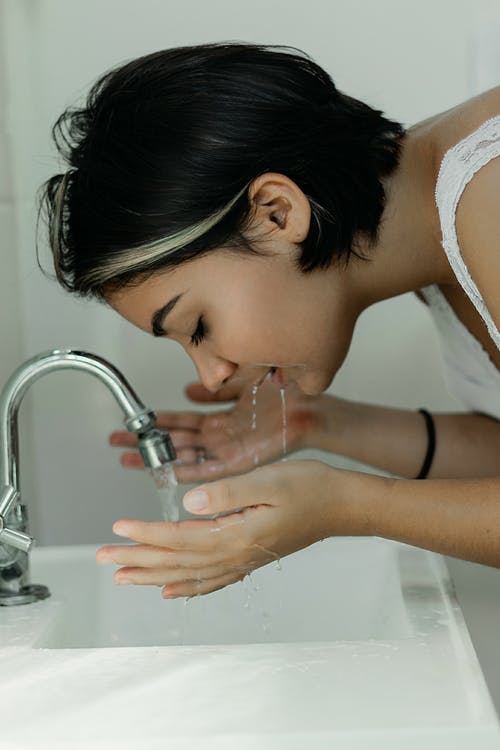 女人洗她的脸用水 · 免费素材图片