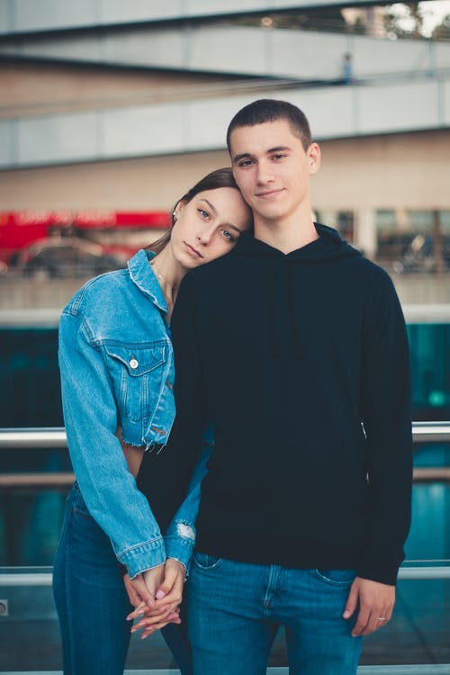 女人把男人的左手放在她的肩膀上时按住男人的左手 · 免费素材图片