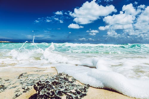 在晴朗的天空下汹涌的海浪海滩风景摄影 · 免费素材图片