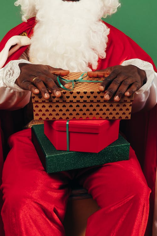 在他的腿上穿上圣诞老人礼物的人 · 免费素材图片